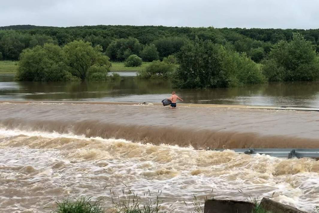  Приморский край Село Благодатное Мужчина на затопленной дороге