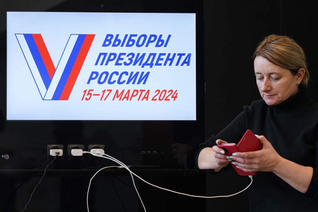 табличка выборы 2024 и женщина в телефоне