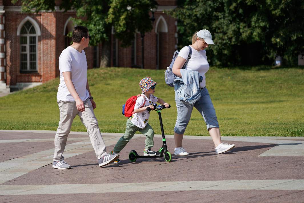 ребенок и его родители гуляют в парке